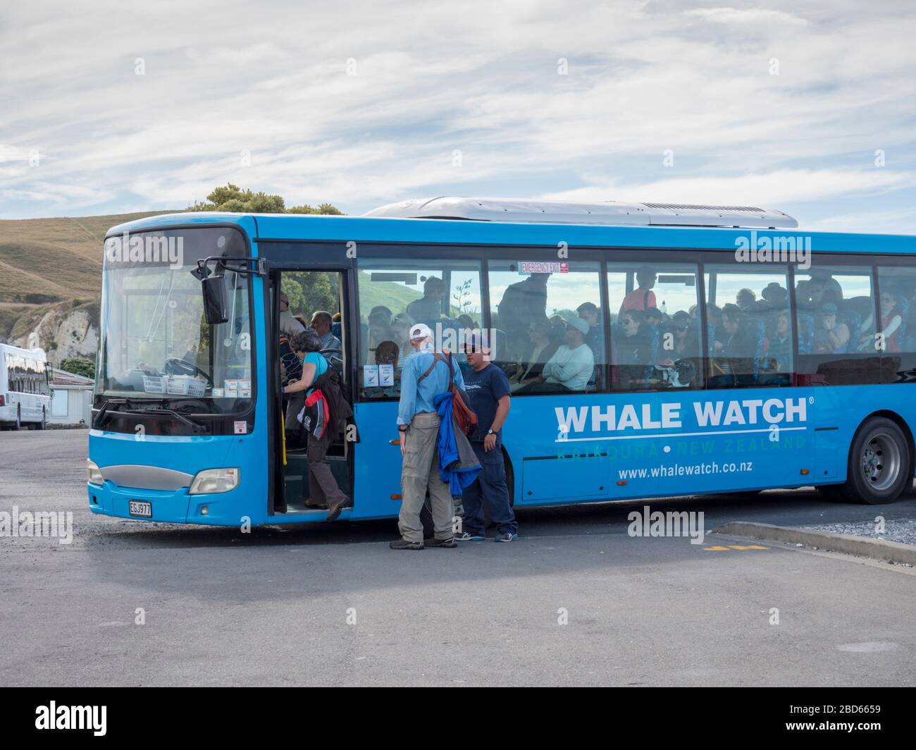 Tourists boarding a bus to travel to a whale watching trip in Kaikoura New Zealand Stock Photo