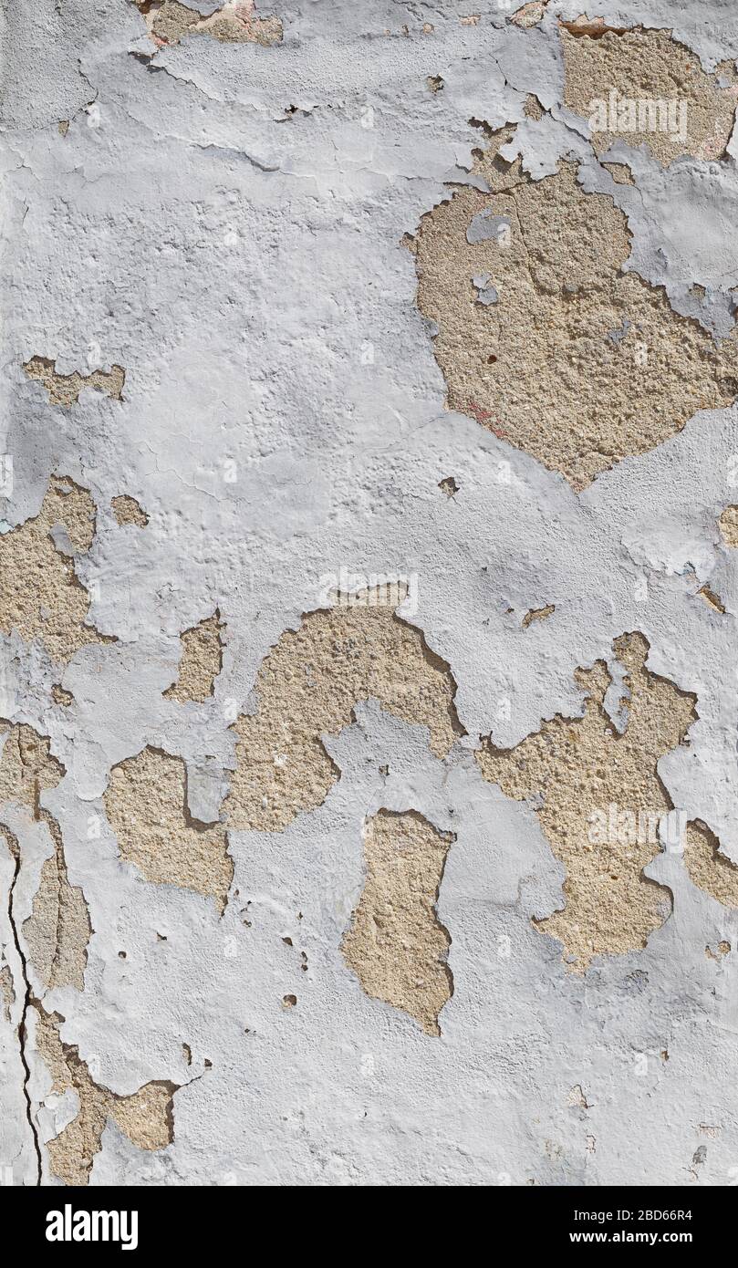 Close-up of a weathered and old concrete wall, white paint is peeling off. High resolution abstract full frame textured background. Stock Photo