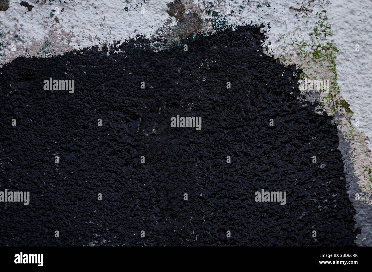 Close-up of a plastered and rough wall painted in white and black. High ...