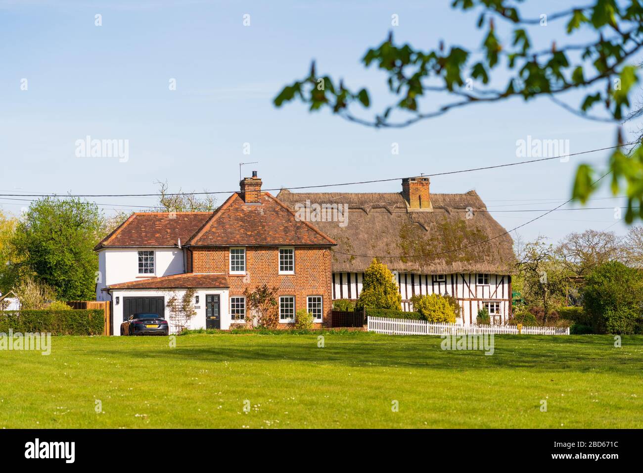 Scene of village green with tiled and thatched house at Green Tye, Much Hadham, Hertfordshire