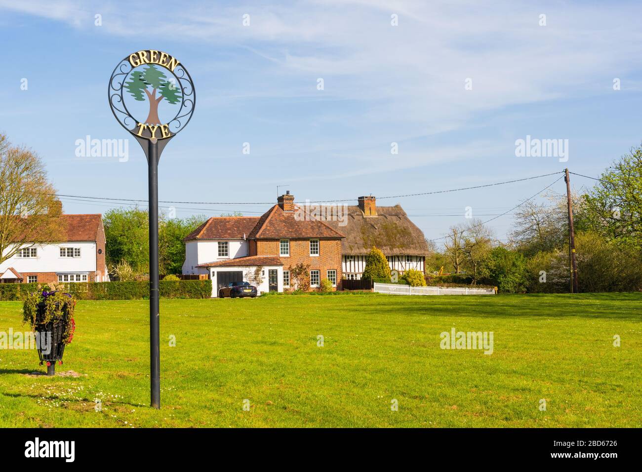 Scene of village green with tiled and thatched house at Green Tye, Much