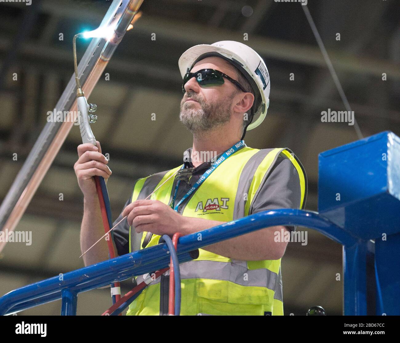 A workman welding in the interior of the new temporary NHS Louisa