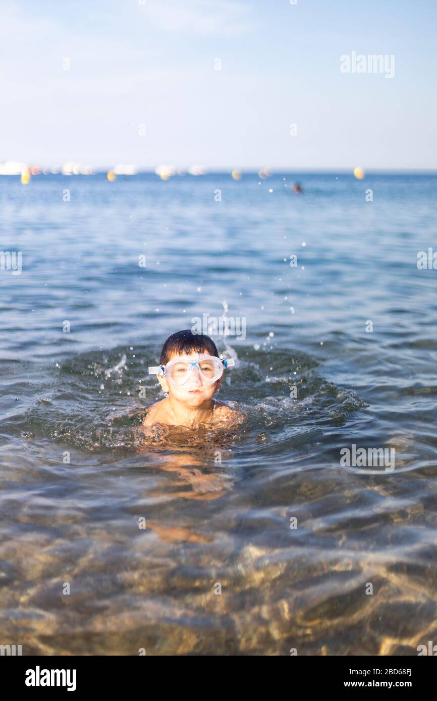 Funny kid with diving goggles on the beach Stock Photo Alamy