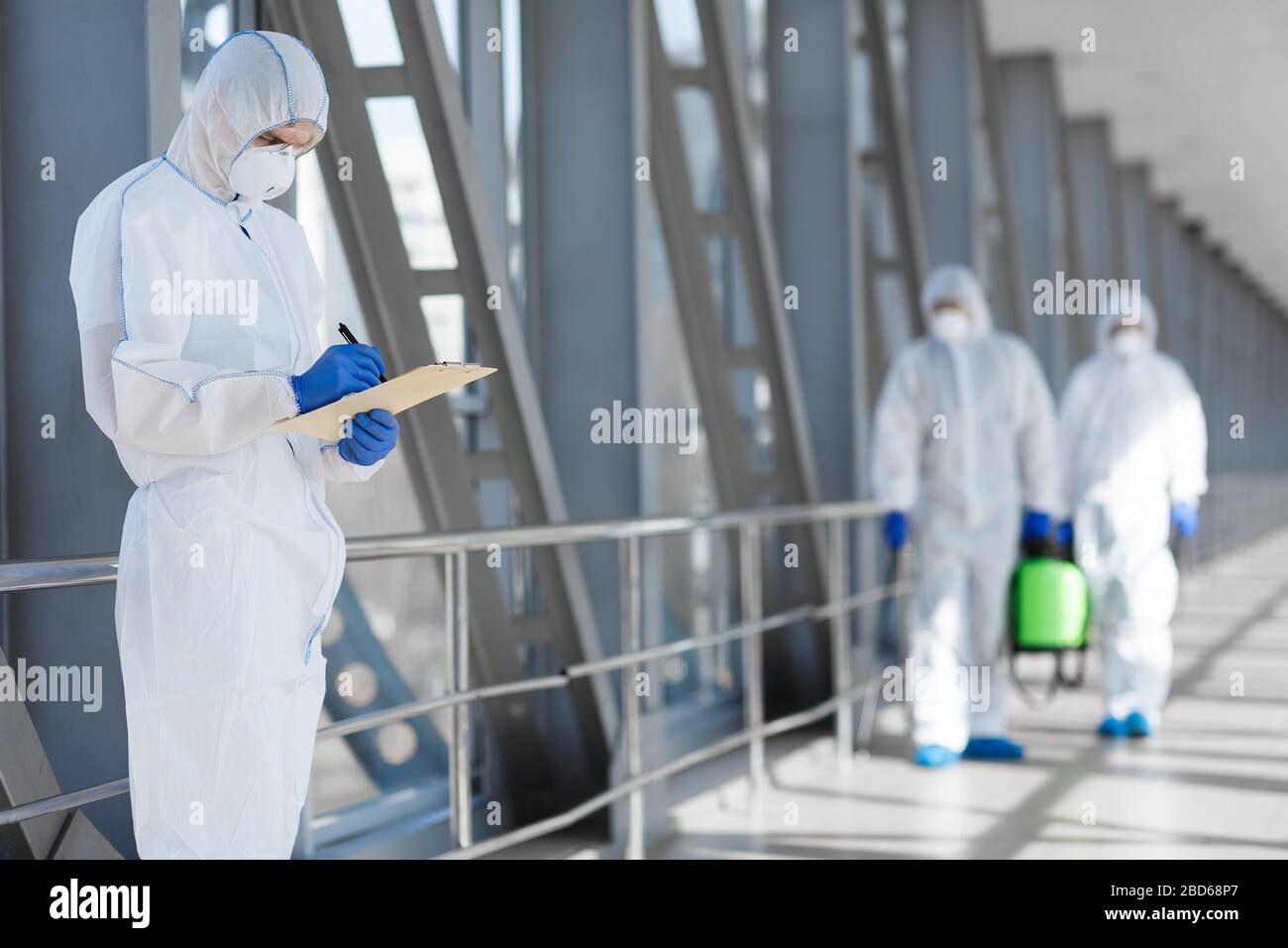 Virologists in protective hazmat suits controlling epidemic Stock Photo