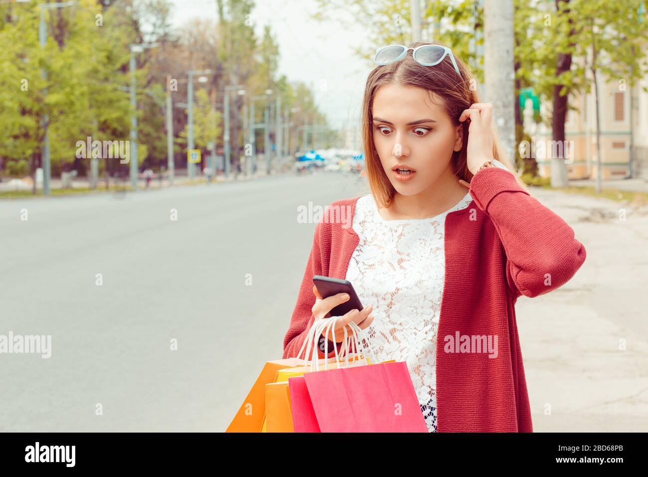 SMS. Closeup portrait funny shocked anxious scared young girl Lady looking at phone seeing bad news photos bully message with disgusting emotion on fa Stock Photo