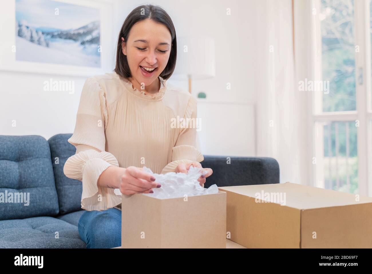 Woman feeling happy with received order at home Stock Photo