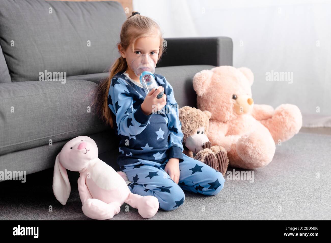 asthmatic kid using inhaler with spacer near soft toys Stock Photo Alamy