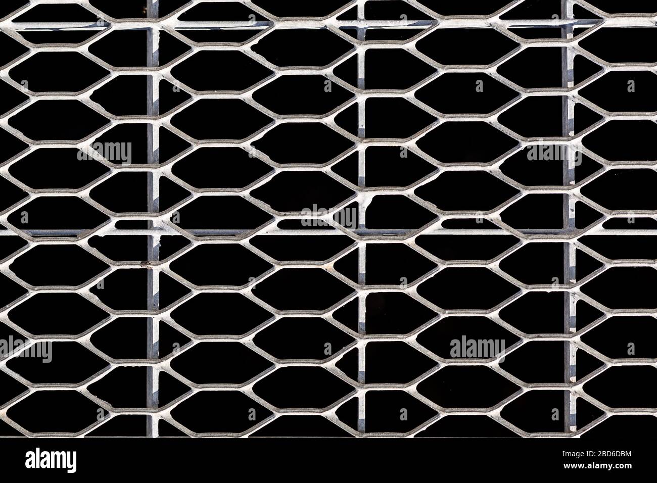 Metal grille on a black background. Geometric patterns. Stock Photo