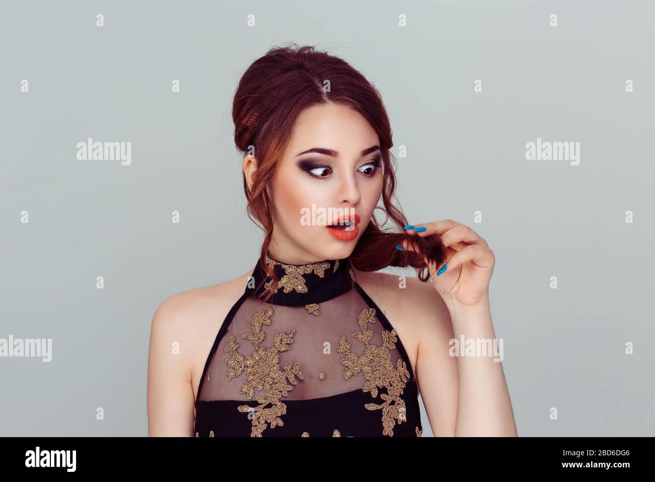 unhappy frustrated young woman surprised she is losing hair, receding hairline. Gray background. Human face expression emotion. Beauty hairstyle conce Stock Photo