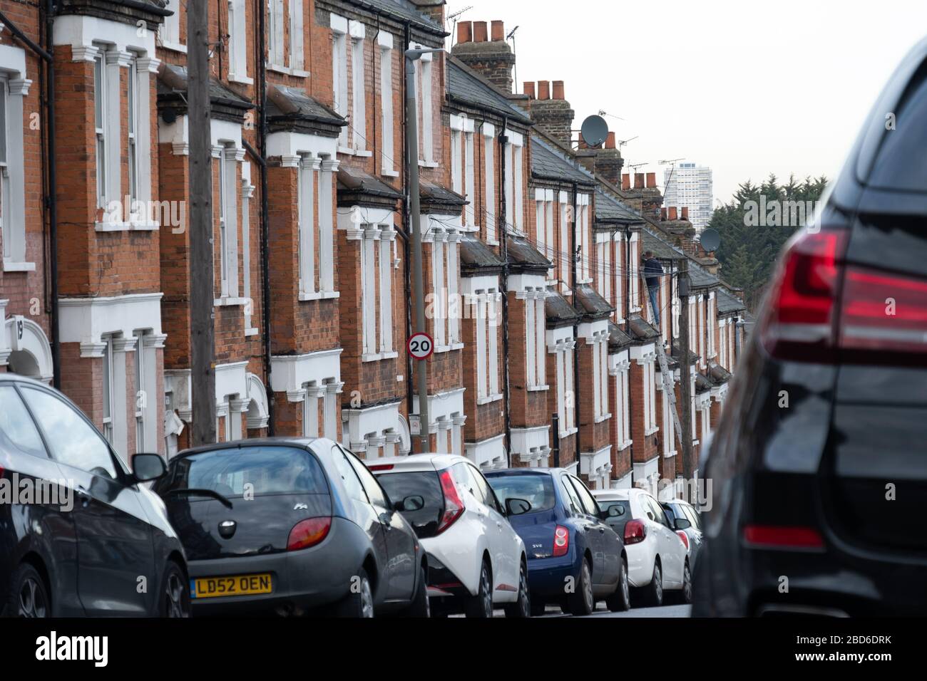 A street of typical British houses with on street parking Stock Photo