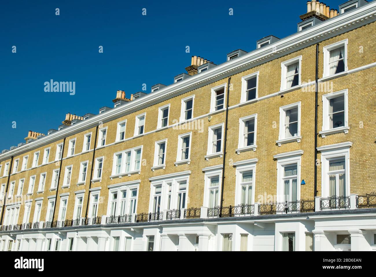 Looking up at modern London townhouses with blue sky Stock Photo