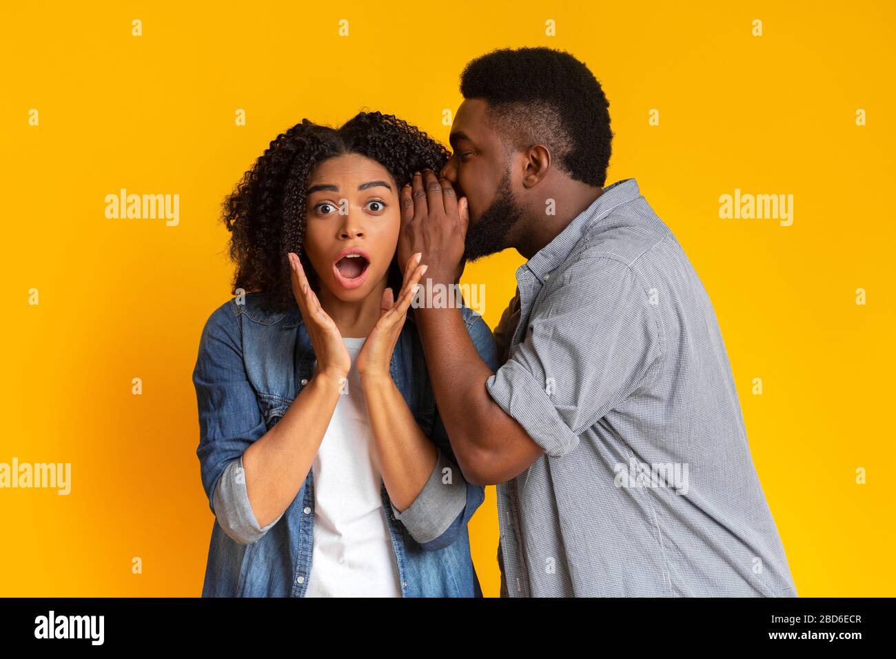Hot Gossip. Black Guy Sharing Secret With His Shocked Girlfriend Stock Photo
