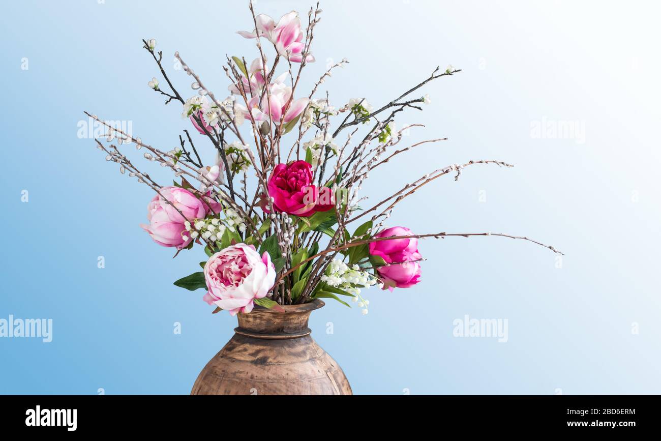 Modern artificial spring flower bouquet in wooden vase. Stock Photo