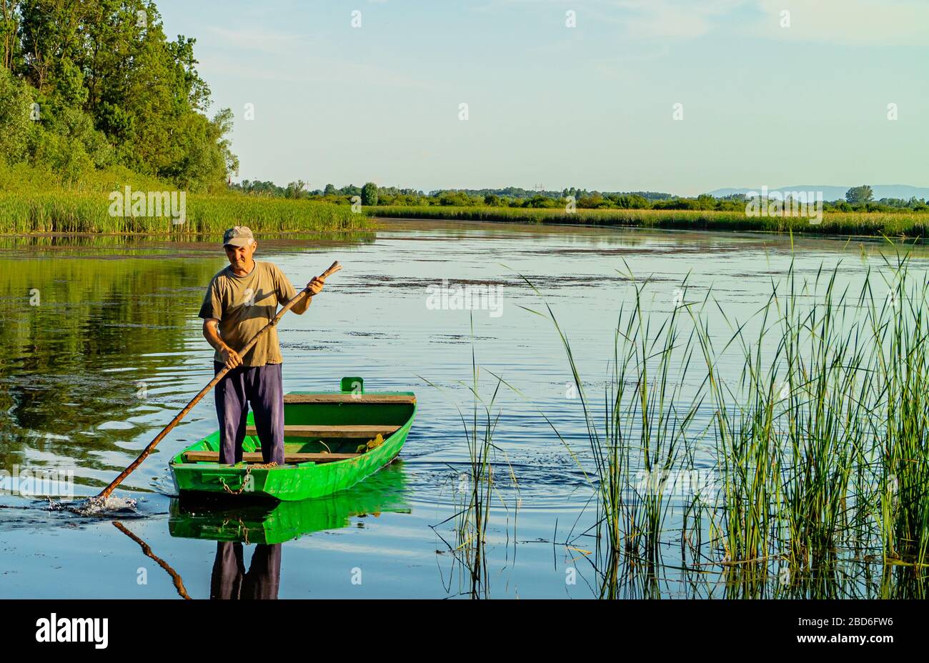 Pushing Raft A Serbian man pushing a traditional raft or boat on the river Zasavica ...