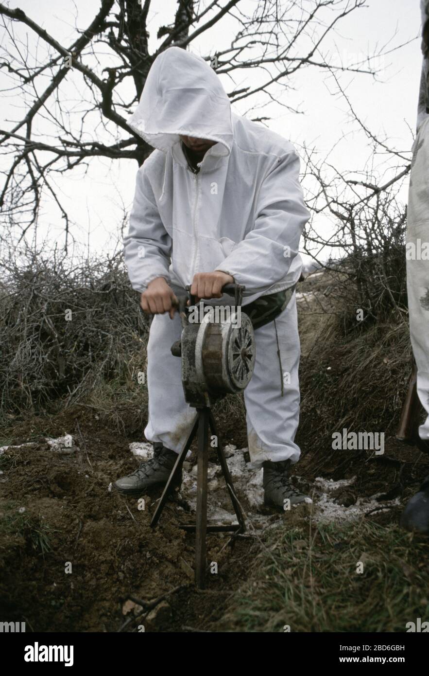 26th January 1994 During the war in central Bosnia: a soldier of the HVO's Rama Brigade turns a hand-cranked air-raid siren in the Bosnian Muslim village of Here, captured two days earlier. Stock Photo