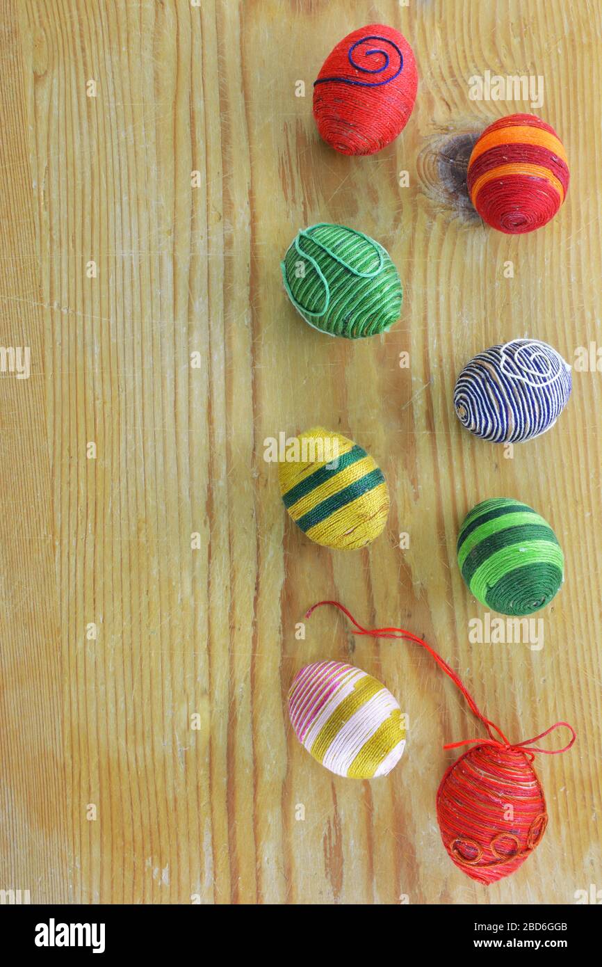 Eggs decorated with threads on  rustic wooden  table Stock Photo