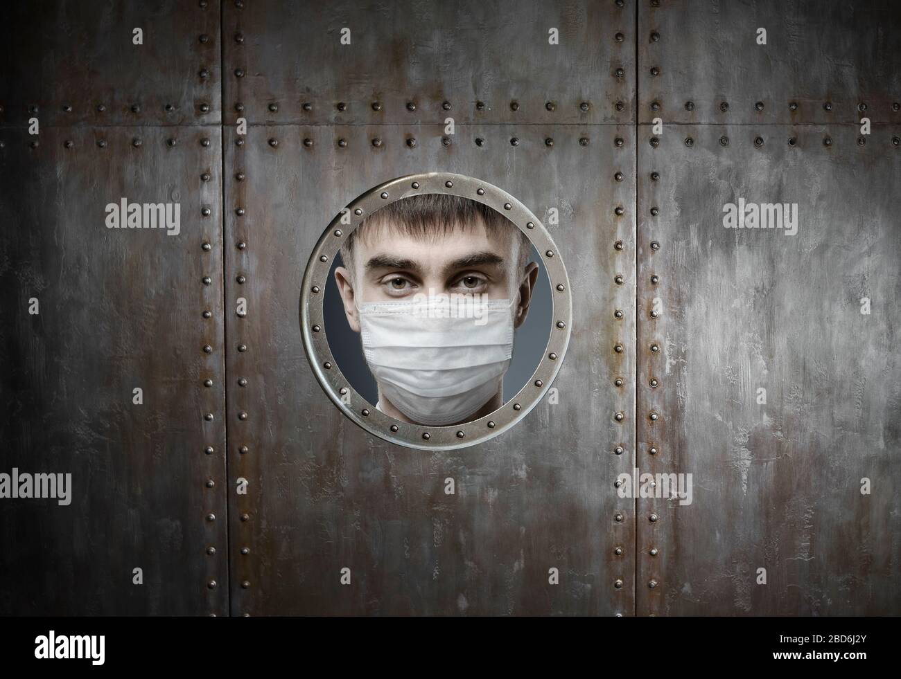 concept coronavirus epidemic, man in medical mask locked in insulator Stock Photo