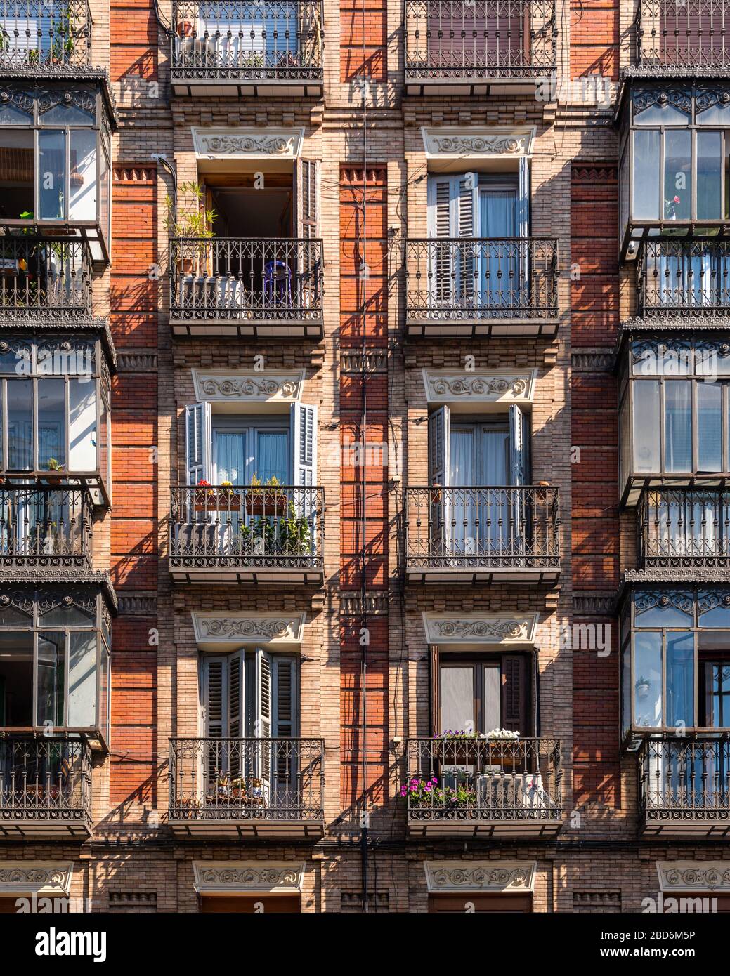 Looking at elegant assorted shuttered balconies on the side of a period building Stock Photo