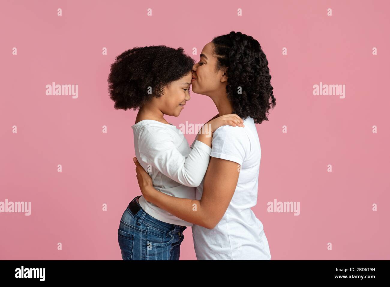 Affectionate Mom. Happy Black Woman Kissing Her Adorable Little Daughter's Forehead Stock Photo