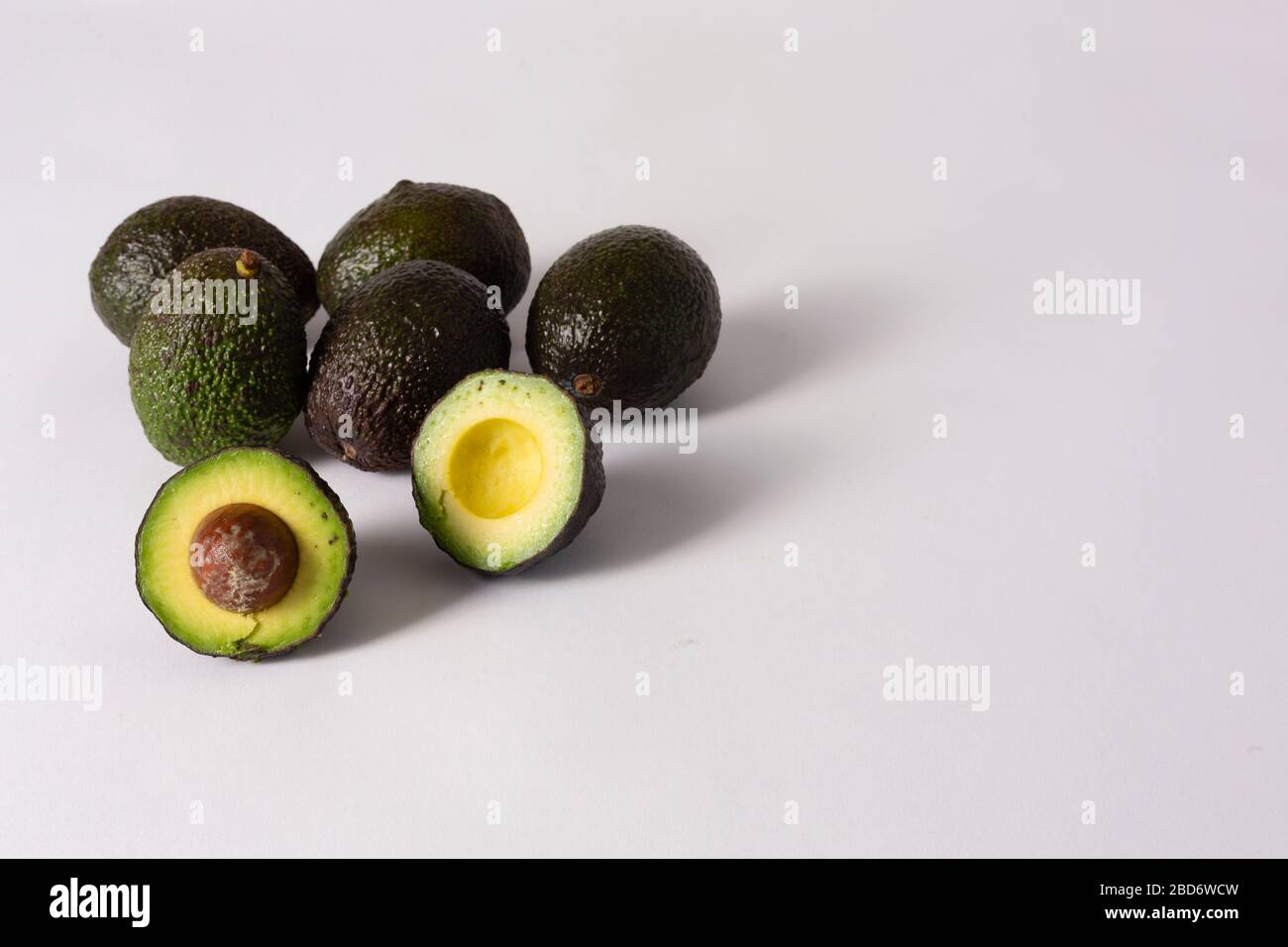 Whole and sliced avocados on white background Stock Photo - Alamy