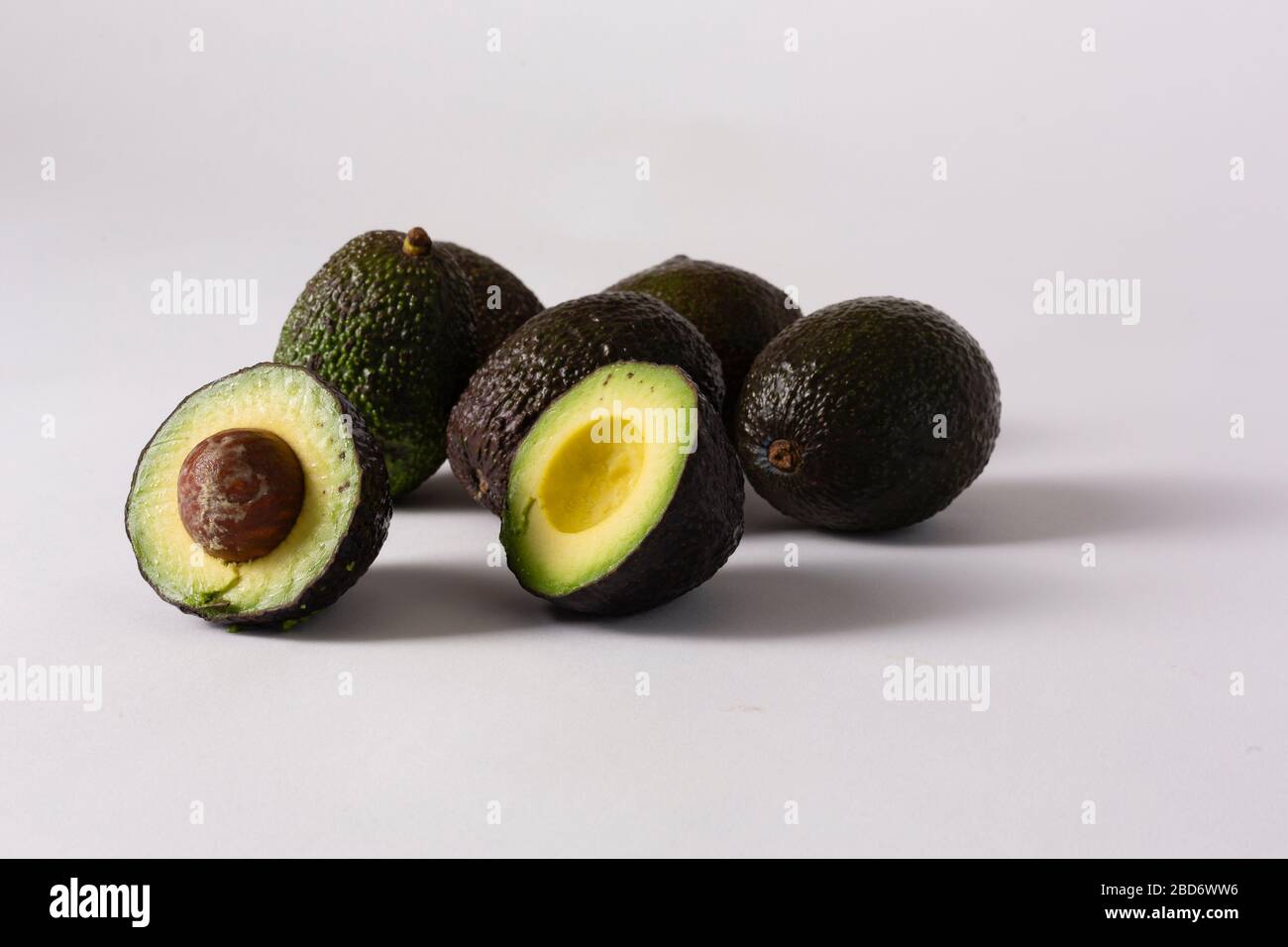 Whole and sliced avocados on white background Stock Photo - Alamy