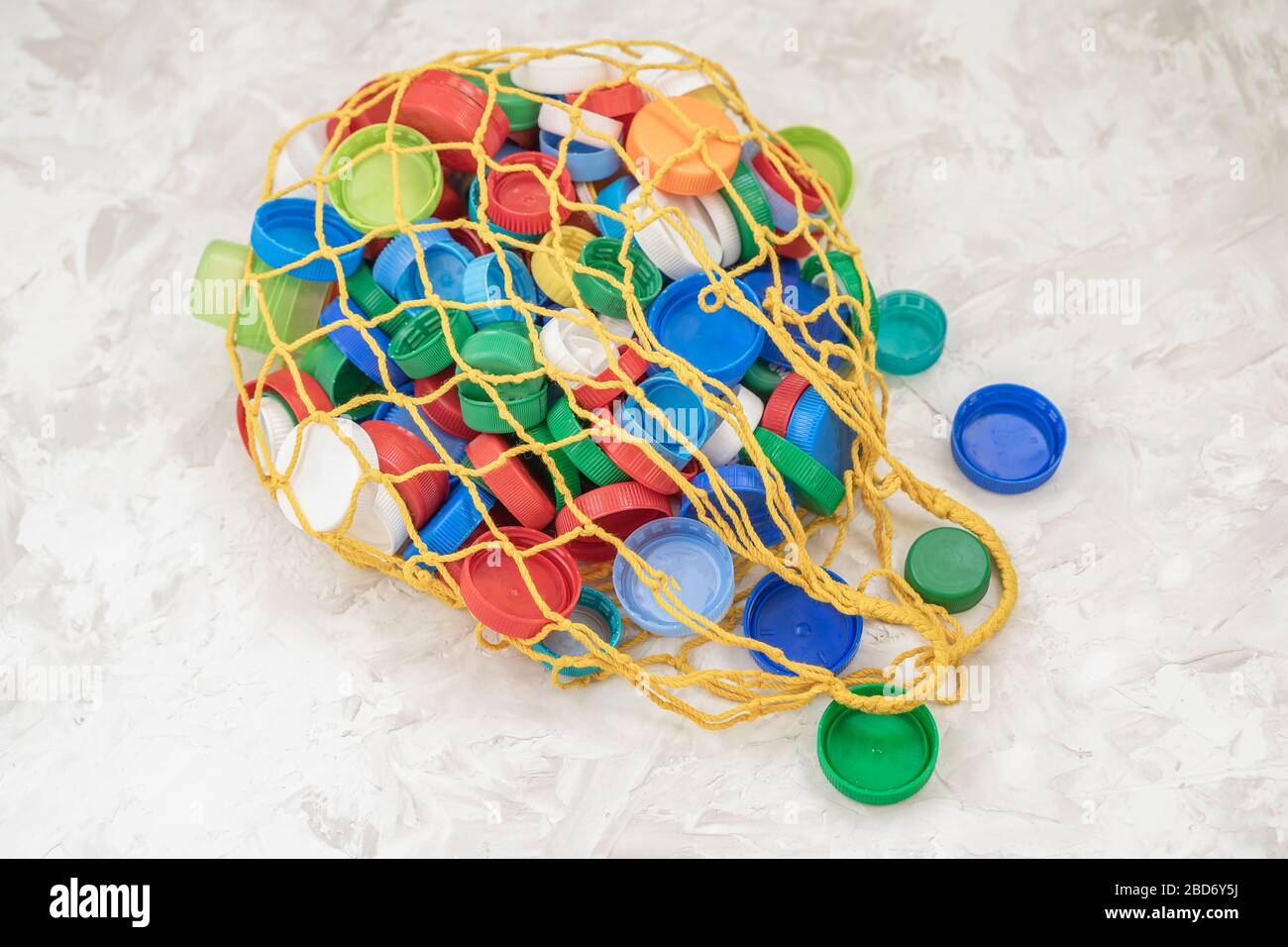 PET plastic bottle caps in mesh string bag stored for recycling