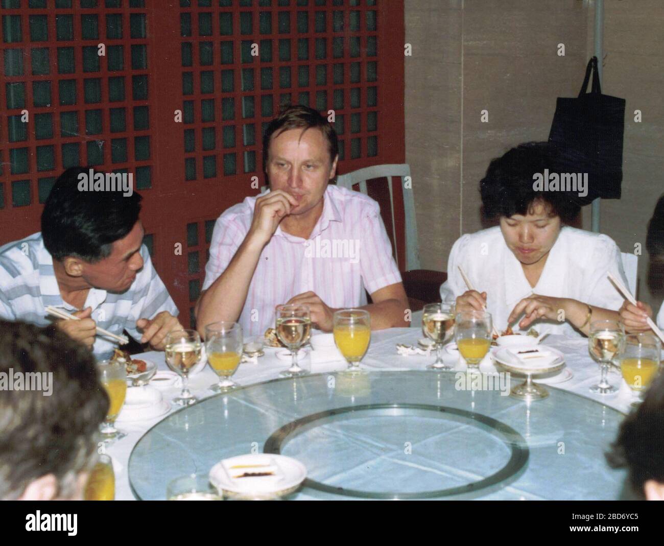 CHINA - 1989: Retro photo shows a group of caucasian - European businessmen and Chinese businessmen have a working lunch. Stock Photo