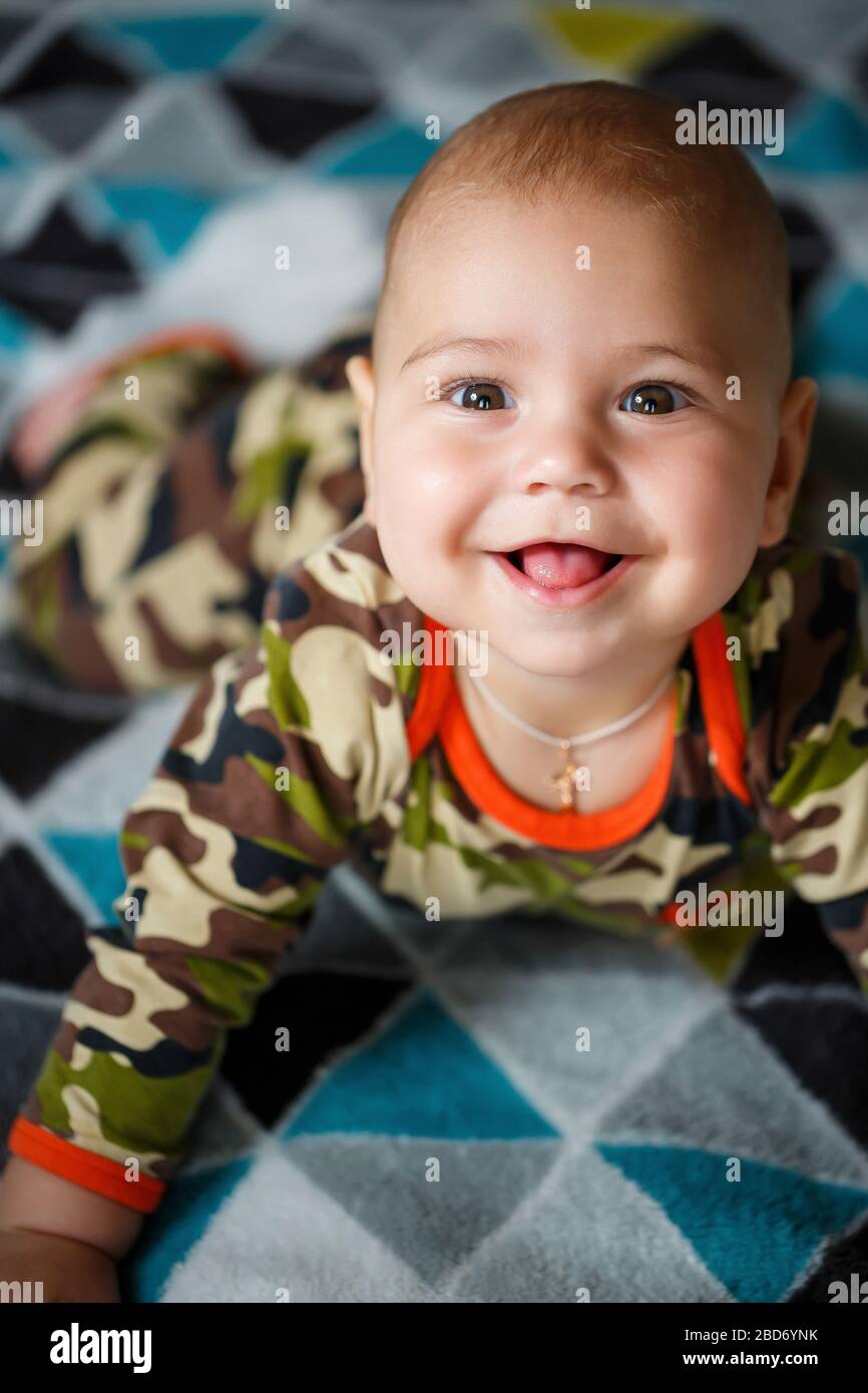 closeup portrait of a little boy age 8 months and is smiling. Dressed