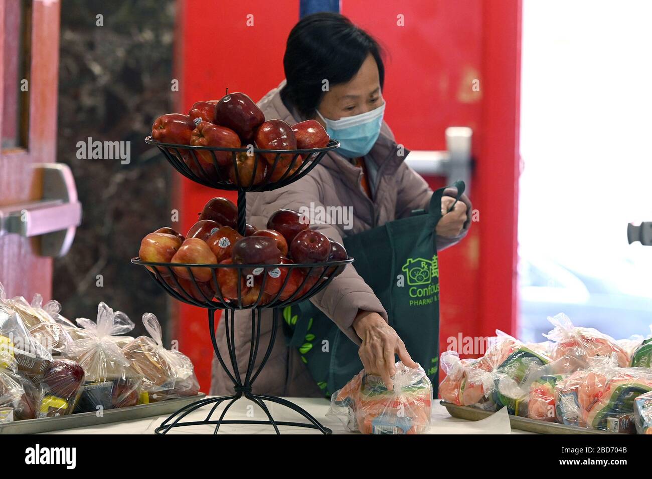 New York, USA. 07th Apr, 2020. A woman picks up frood from the Meal Hub at PS1 in lower. Manhattan, where anyone can take a “Grab and Go” Meal, in New York, April 7, 2020. Mayor de Blasio reiterated that the program is there for childrena and adults, and anyone can get food during the COVID-19 pandemic at designated Meal Hiubs in their neighborhood. (Anthony Behar/Sipa USA) Credit: Sipa USA/Alamy Live News Stock Photo