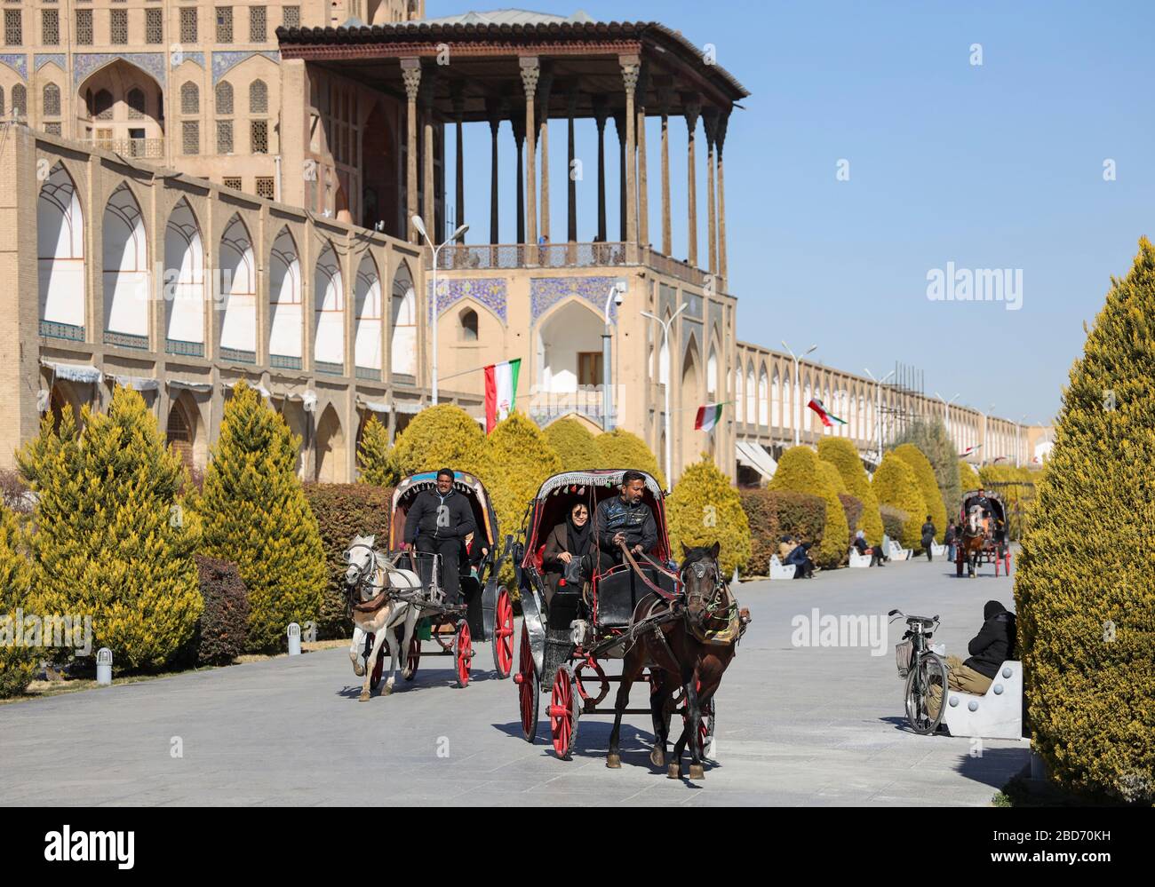 Horse drawn carriages on at Meidan-e Emam, Naqsh-e Jahan, Imam Square, Ali Qapu palace in the background, UNESCO World Heritage Site, Esfahan, Isfahan Stock Photo