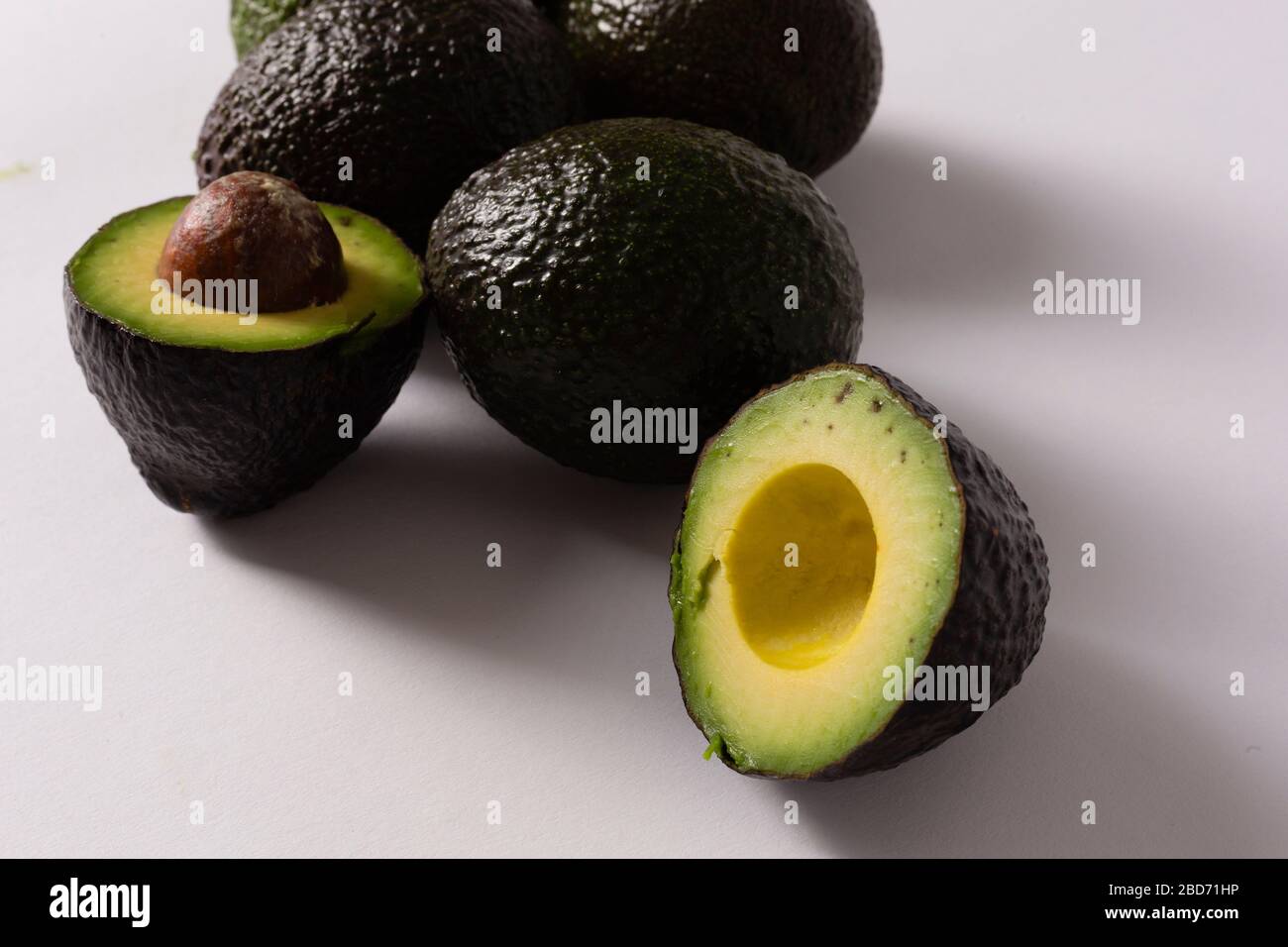 Whole and sliced avocados on white background Stock Photo - Alamy