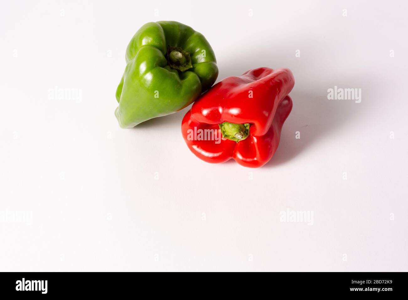 Green and red peppers on white background Stock Photo - Alamy