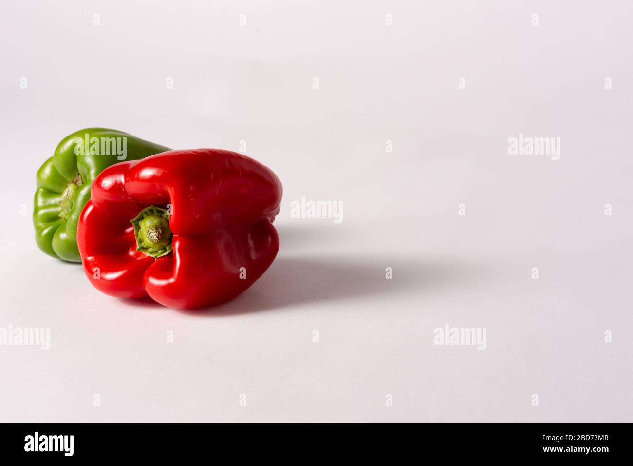 Green and red peppers on white background Stock Photo - Alamy