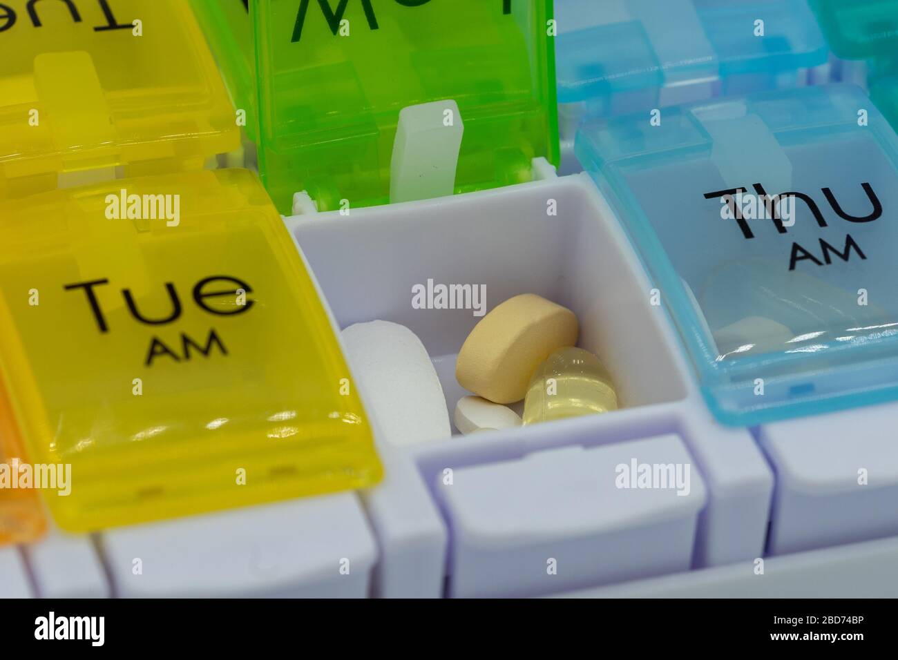 A close up of pills inside a pill box or medication box used for counting  out medication for the week Stock Photo - Alamy