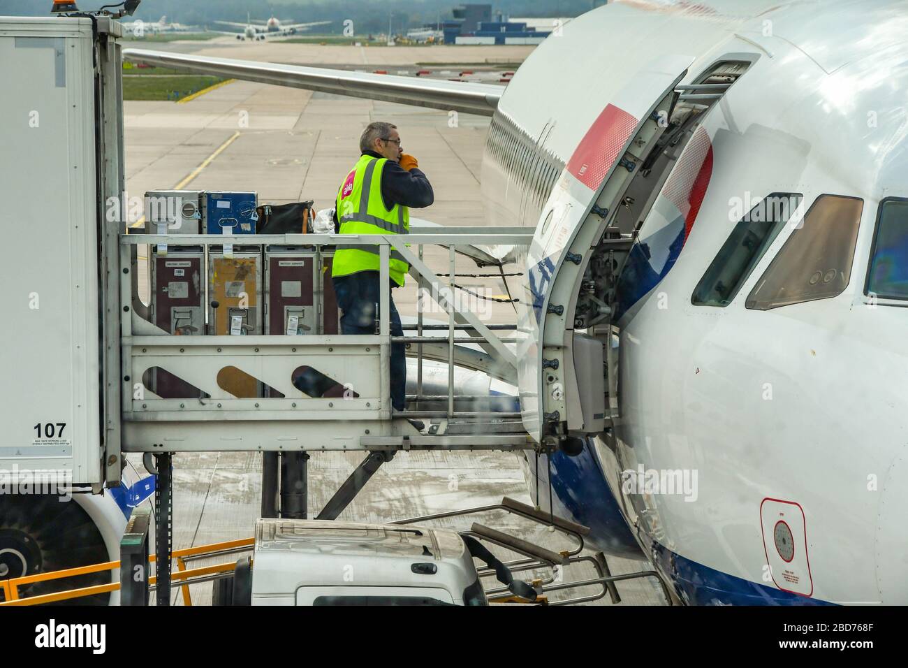 LONDON GATWICK AIRPORT, ENGLAND - APRIL 2019: Person loading a British Airways Airbus jet with in flight catering supplies at London Gatwick Airport Stock Photo