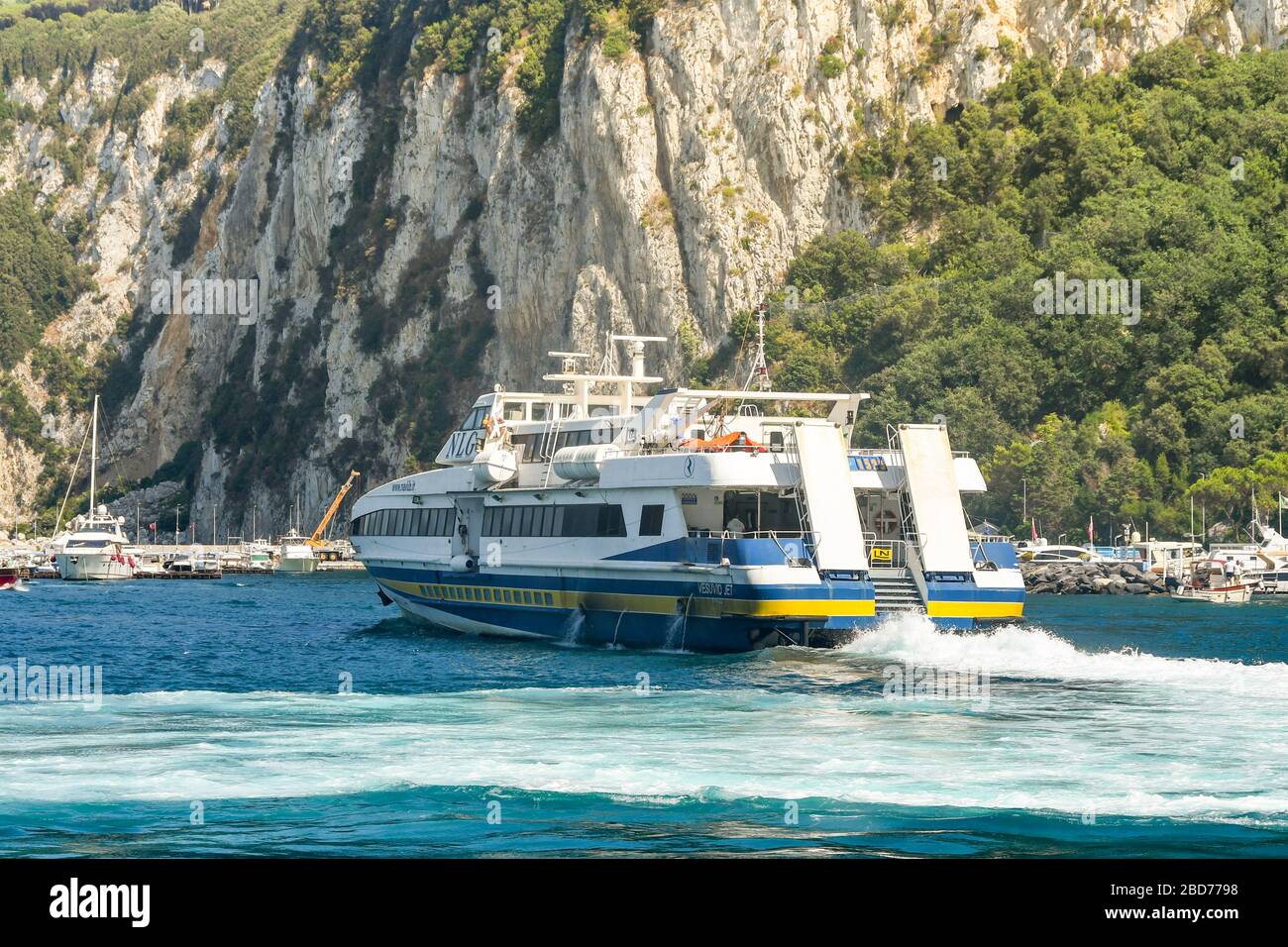 ISLE OF CAPRI, ITALY - AUGUST 2019: Fast passenger ferry departing the port on the Isle of Capri. Stock Photo