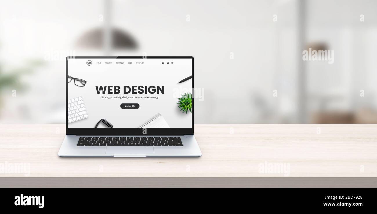 Web design studio promo web site on laptop display on office desk concept Stock Photo