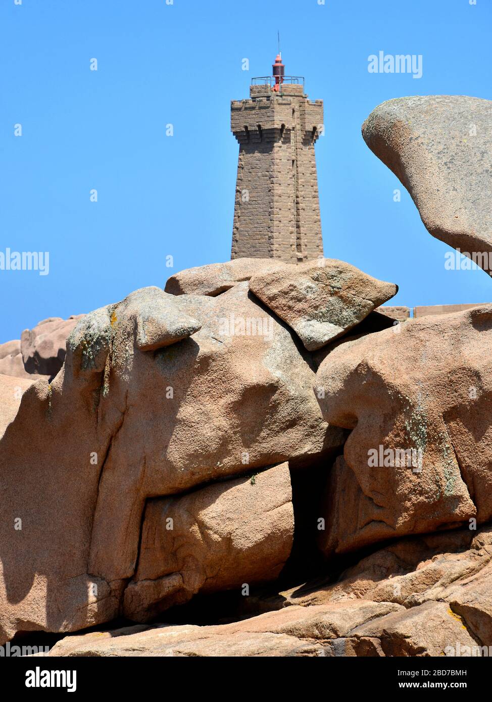 Mean Ruz lighthouse on the famous Pink Granite Coast (côte de granite rose in french) behind big rocks at Ploumanac'h in France Stock Photo