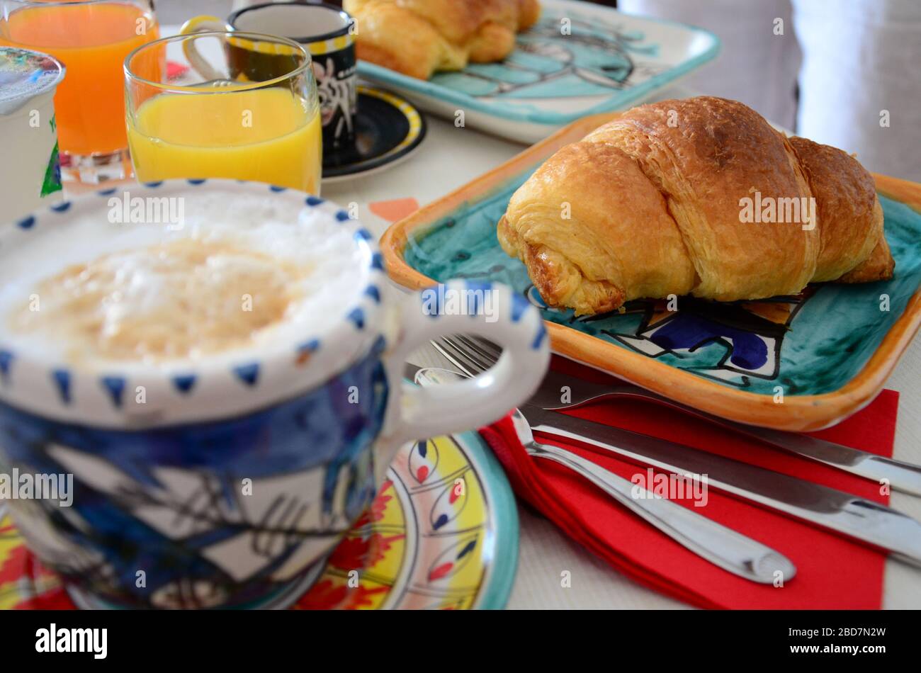 Typical italian breakfast with cappuccino, cornetto, espresso and orange juice. Stock Photo