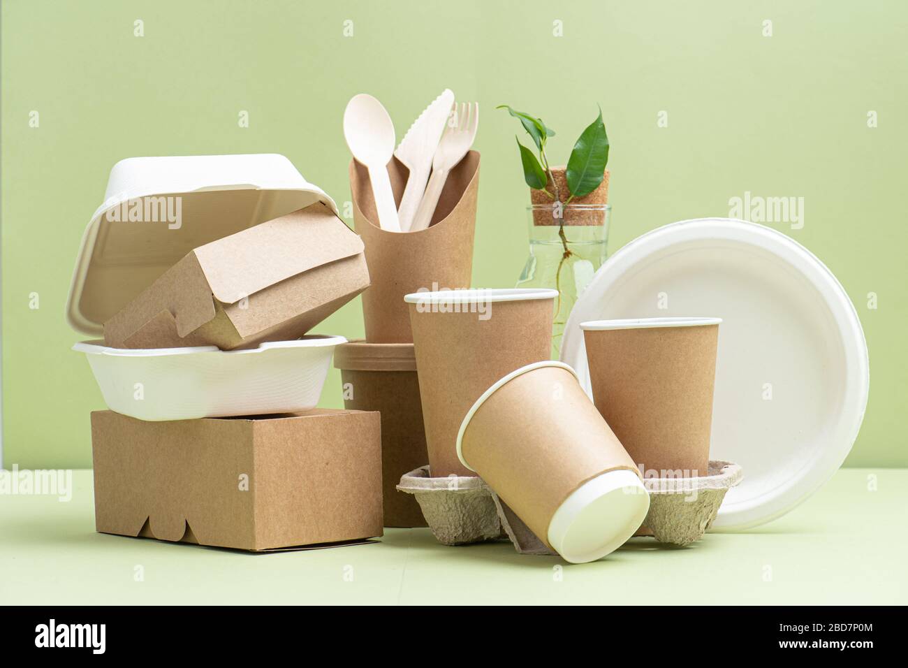 Ecofriendly disposable containers for food and drinks over green Stock