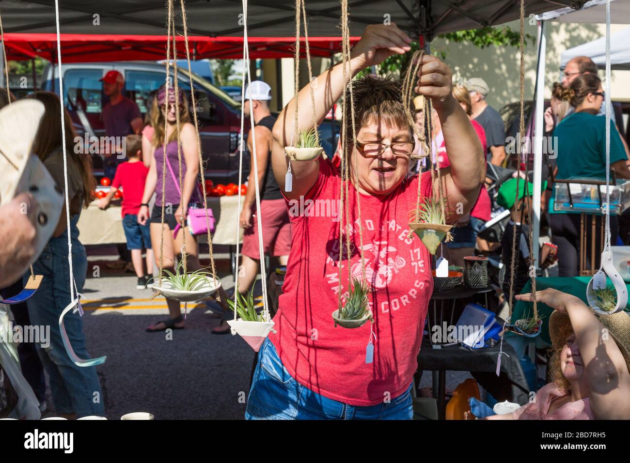 A vendor in a red shirt at Fort Wayne's Farmers Market displays her air plants in downtown Fort Wayne, Indiana, USA. Stock Photo
