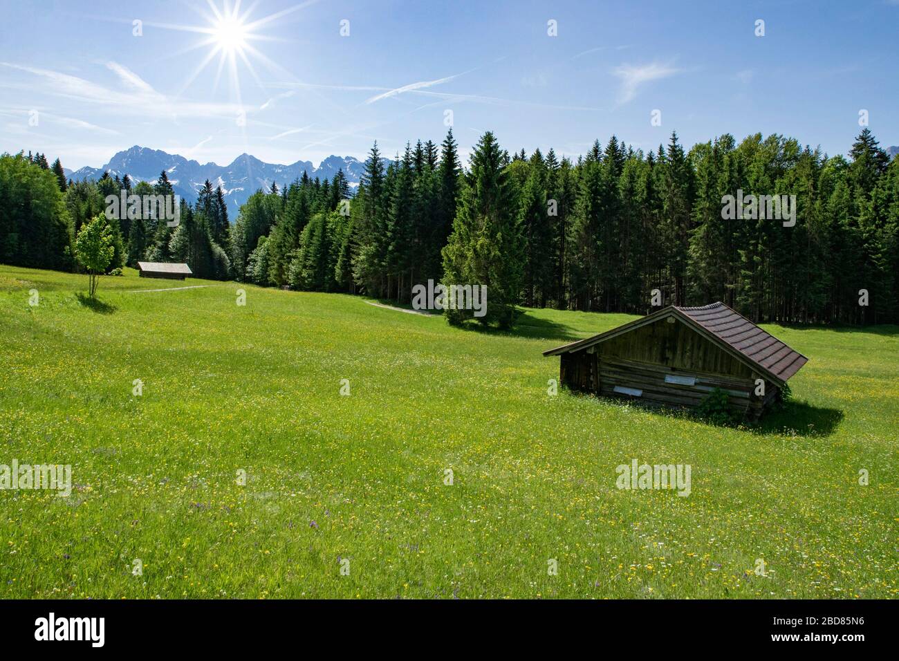 meadow and haystack in spring, Karwendel mountains in background, Germany, Bavaria, Estergebirge Stock Photo
