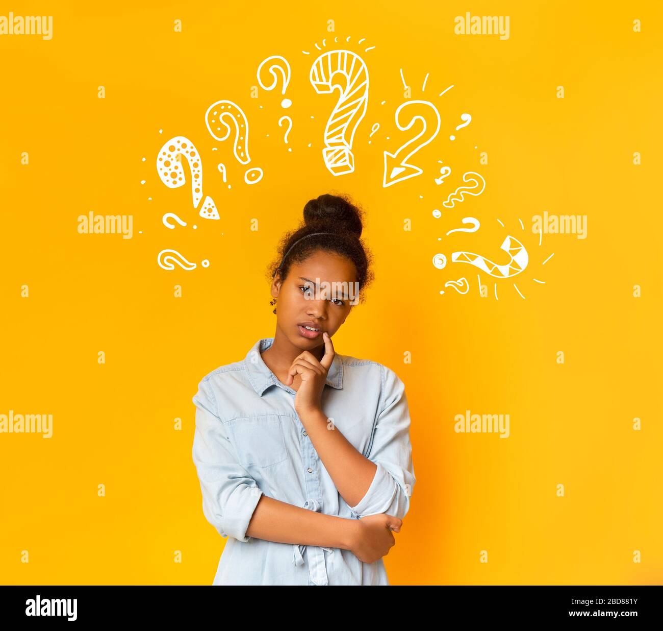 Puzzled pensive young african american teen girl with question marks