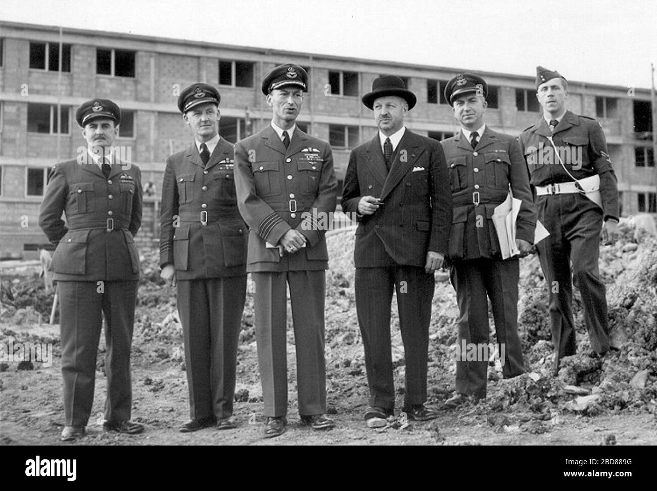 'English: Royal Canadian Air Force permanent married quarters (PMQs) construction inspection by Royal Canadian Air force staff, St. Avold, France, 1954. Air Vice Marshal W.A. Curtis is in civilian suit. These married quarters accommodated dependents of service personnel from RCAF Station Grostenquin, France.; 1954; http://www.c-and-e-museum.org/grostenquin/photos/PMQs/pmqs-1.jpg; Government of Canada; ' Stock Photo