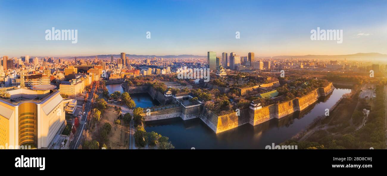 Aerial panorama at sunrise in Osaka city of Japan around historic park with old castle and new modern skyscrapers. Stock Photo