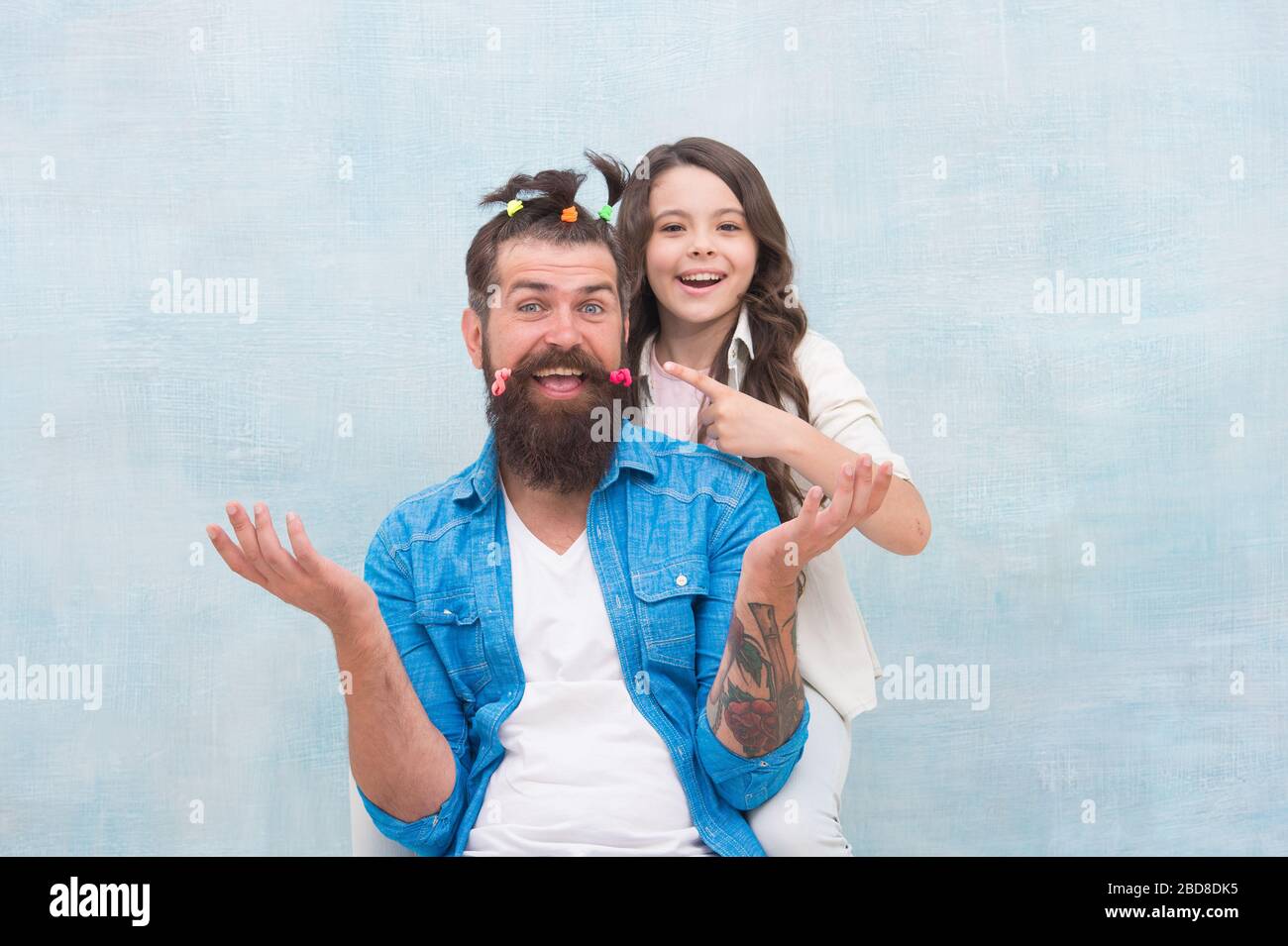 Having fun. happy family day. small girl play with dad. bearded man father having fun with kid. childrens day. love and trust. daughter and father with funny hairdo. hairdresser and barbershop. Stock Photo