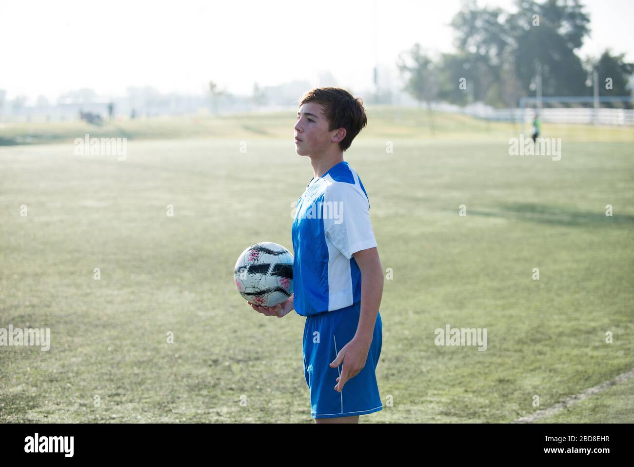 Teen soccer player holding ball and ready for a throw in Stock Photo
