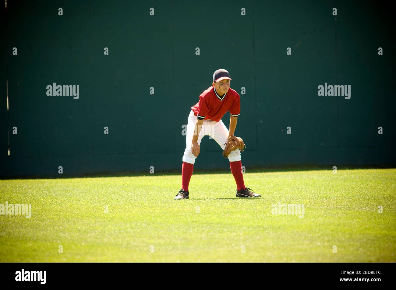 Boy in ready position in the outfield of a baseball field Stock Photo
