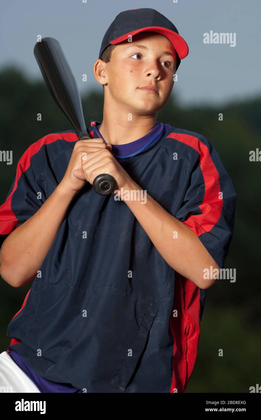 Portrait of a baseball player holding his bat wearing a warm up jacket Stock Photo