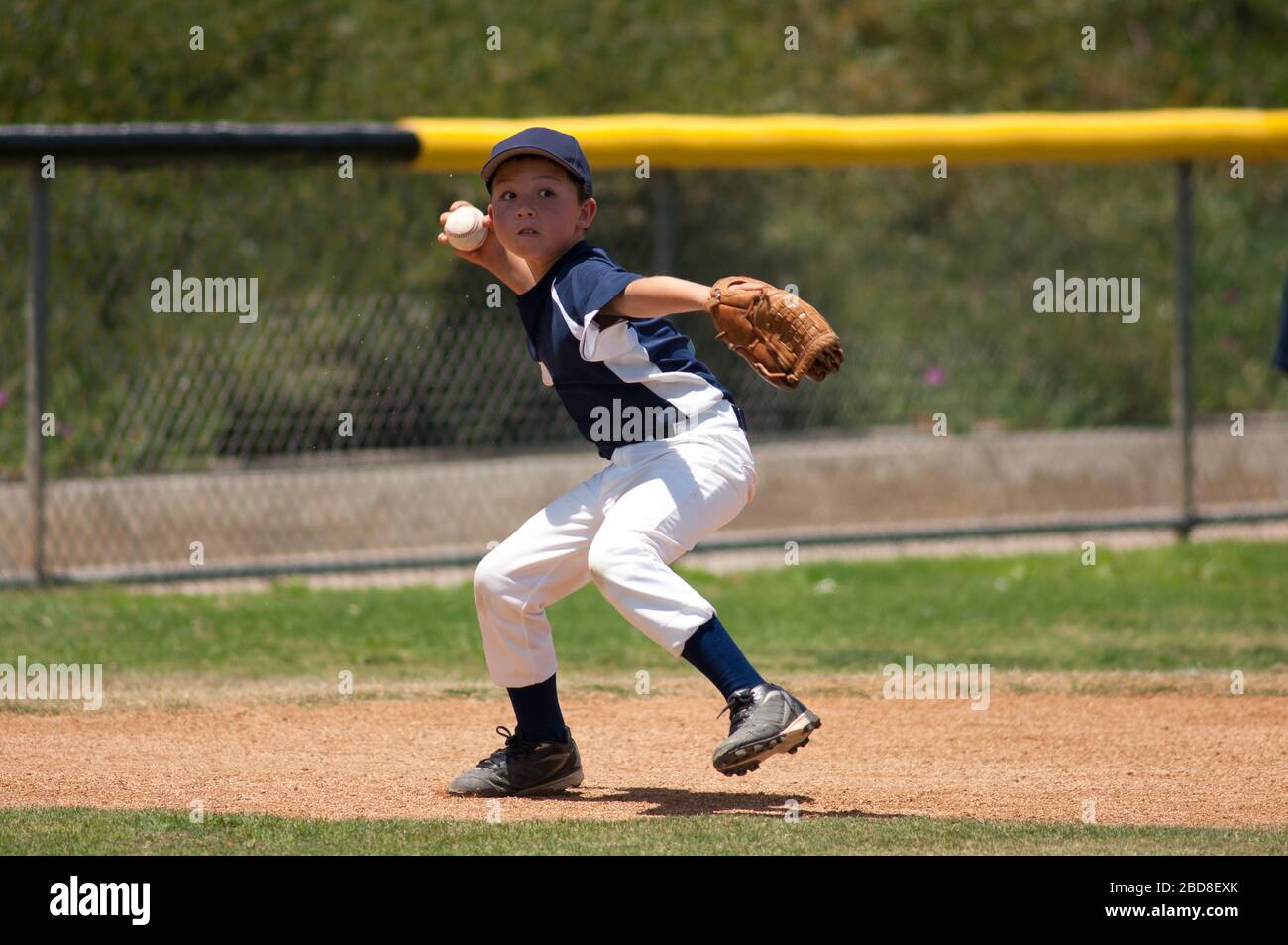 Little League baseball infielder ready to throw to first base Stock Photo